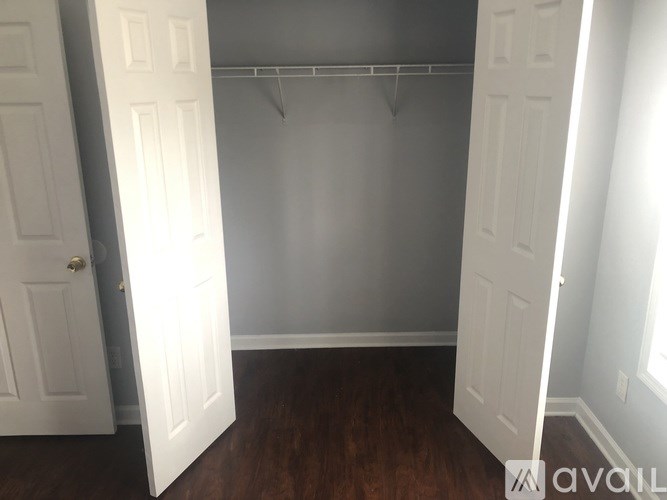 A room with a white door and a wooden floor.