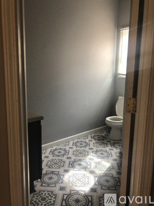A bathroom with a toilet and a tiled floor.