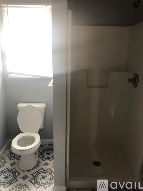 A white toilet in a bathroom with a tiled floor.