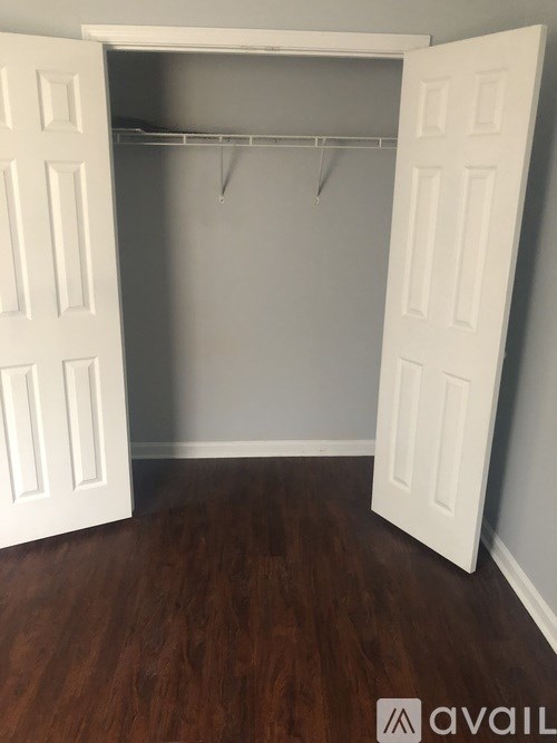 A room with a white door and a coat rack.