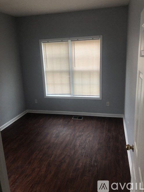 A room with a window and wooden flooring.