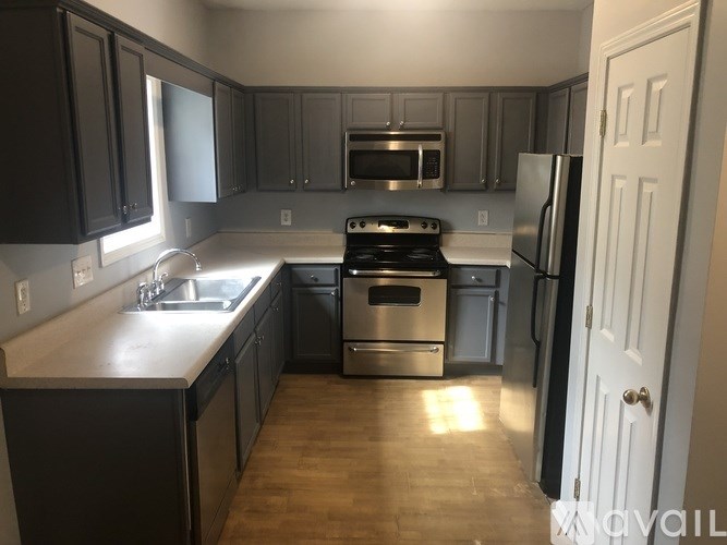 A kitchen with dark wood cabinets and stainless steel appliances.