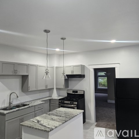 A kitchen with a marble island in the middle.
