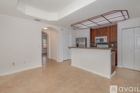 A kitchen area with a white counter and a refrigerator.