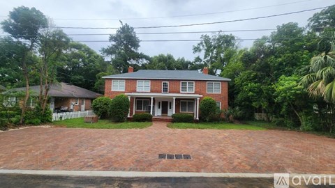 A red brick house with a white door and windows.