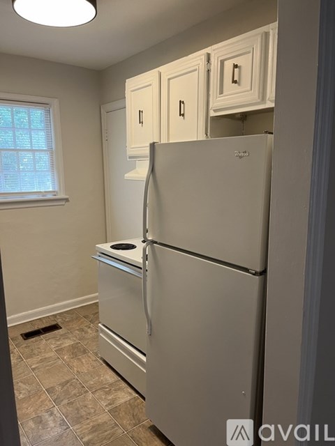 A white refrigerator in a kitchen with a window.