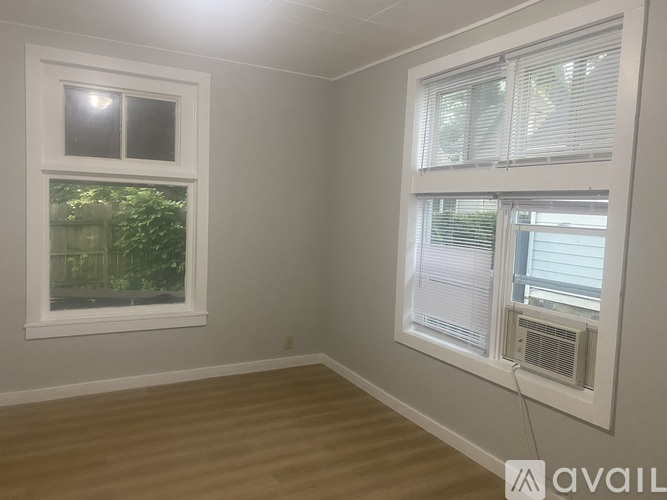 A room with a window and a wall-mounted air conditioner unit.