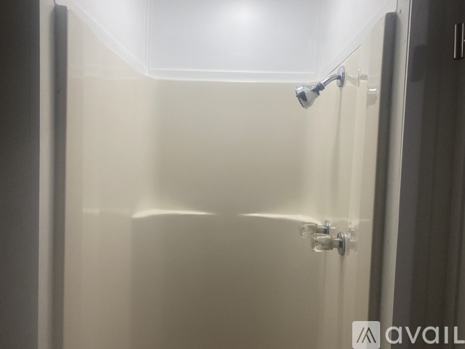 A shower stall with a glass door and a silver handle.