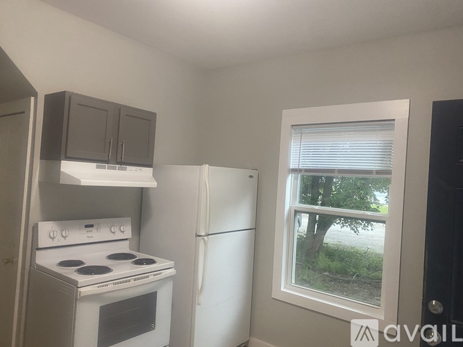 A small kitchen with a white stove and a white refrigerator.