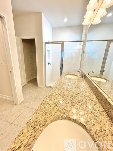 A bathroom with a large mirror and lights above it.