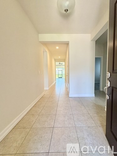A long hallway with tiled floors and white walls.