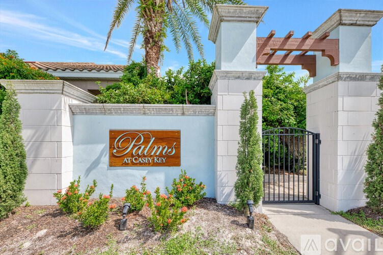 The entrance to Palms at Casey Key is framed by white columns.