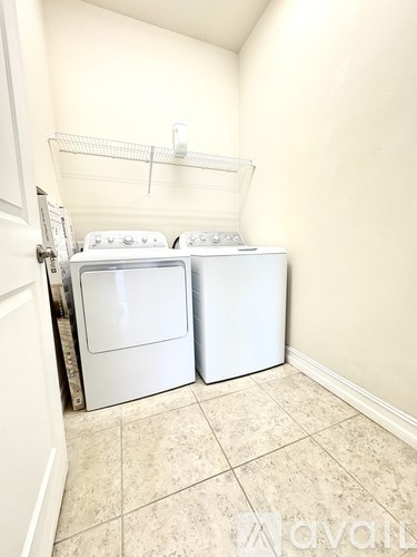 A small laundry room with a washer and dryer.