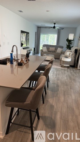 A kitchen with a long table and chairs.