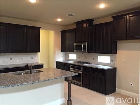 A kitchen with black cabinets and granite countertops.