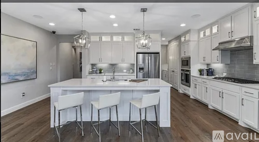 A modern kitchen with white cabinets and a large island.