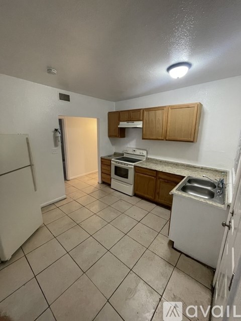 A kitchen with white appliances and wooden cabinets.