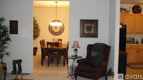 A living room with a red chair and a lamp.
