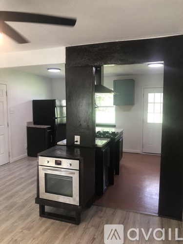 A kitchen with black cabinets and a stove top oven.