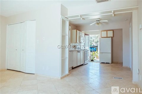 A kitchen with white cabinets and a ceiling fan.