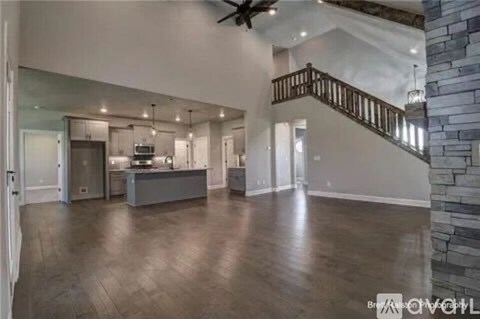 A spacious open floor plan with a kitchen, dining area, and a staircase.