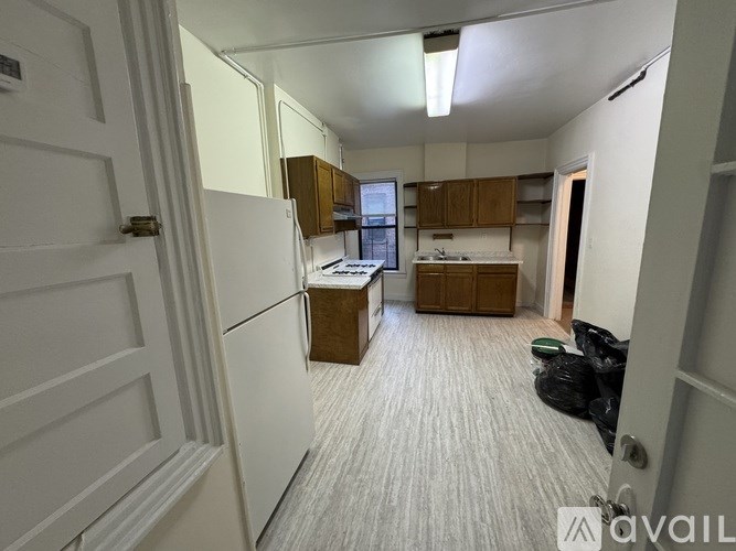 A kitchen with a white refrigerator and wooden cabinets.