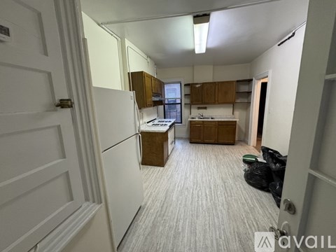 A kitchen with a white refrigerator and wooden cabinets.