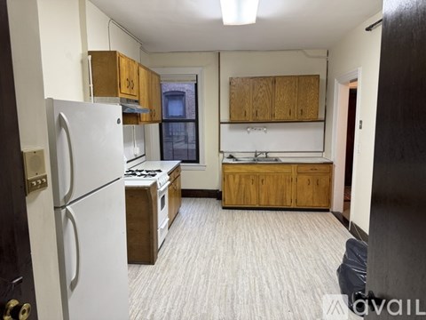 A kitchen with a white refrigerator and wooden cabinets.