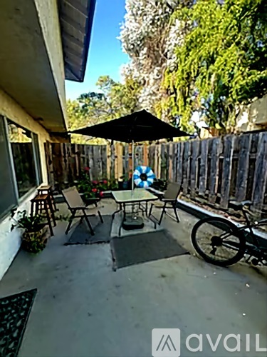 A patio with a table, chairs, and a bicycle.