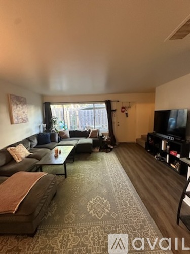 A living room with a brown rug and a brown couch.