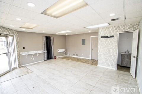 A spacious room with a white ceiling and floor, and a wall with a patterned design.