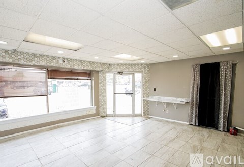 A spacious room with a large window and a bench.