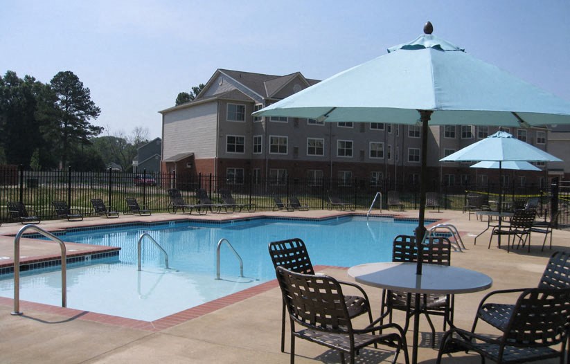 a swimming pool with tables and chairs and umbrellas