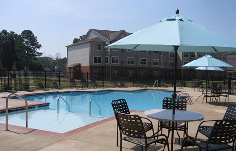 a swimming pool with tables and chairs and umbrellas