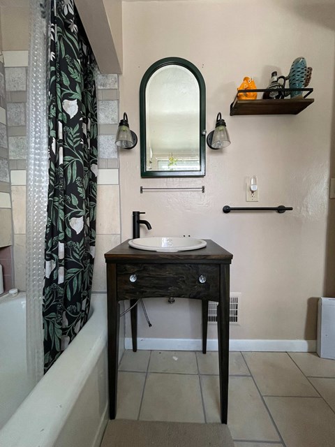 A bathroom with a sink and a mirror.