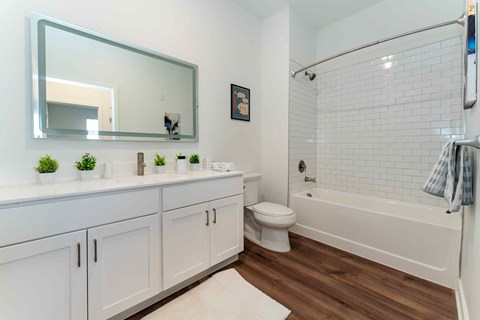 A white bathroom with a white toilet and a white bathtub.