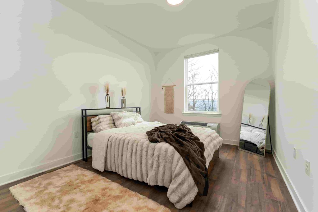 A bedroom with a large bed and a window.