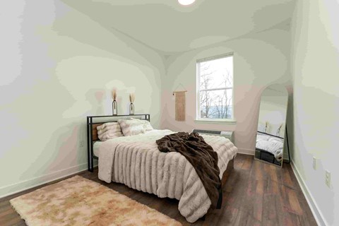A bedroom with a large bed and a window.