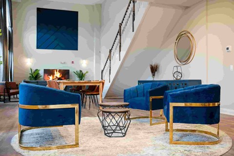 A living room with blue chairs and a fireplace.