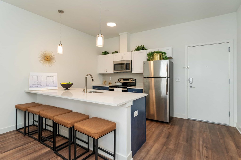 A kitchen with a white countertop and a stainless steel refrigerator.