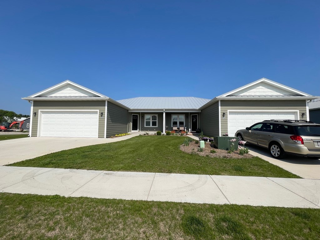 A house with a silver car parked in front.