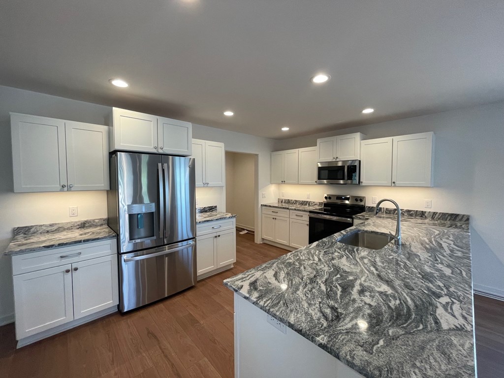 A kitchen with granite countertops and stainless steel appliances.