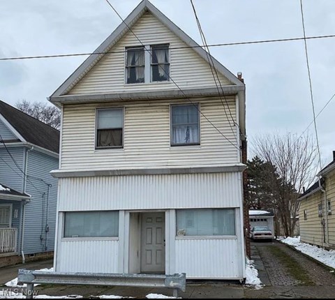 A two-story house with a grey door and windows.