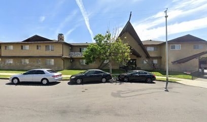 Two cars are parked in a parking lot in front of a building.