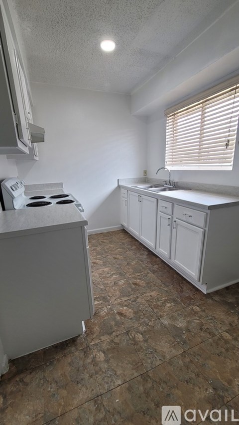 A kitchen with a stove top oven and a sink.