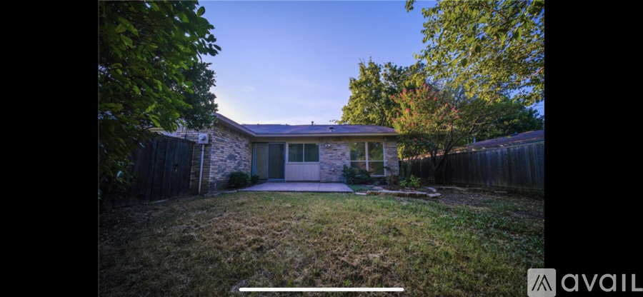 A house with a fence and trees in the background.