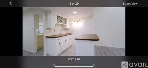 A kitchen with white cabinets and a wooden countertop.