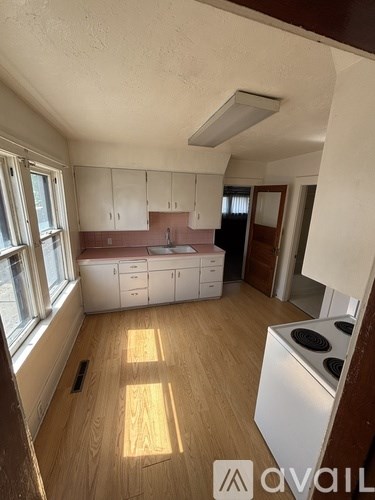 A kitchen with white cabinets and a stove top oven.