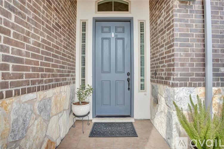 A grey door is in front of a brick wall.