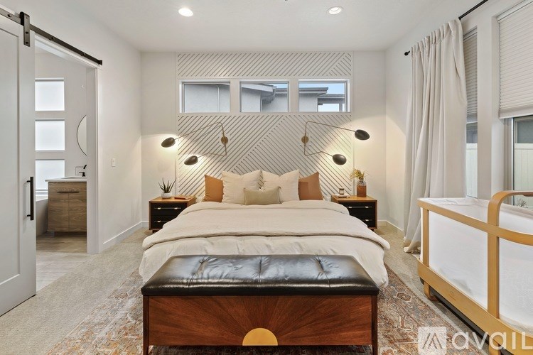 A bedroom with a large bed and a bench in front of it.